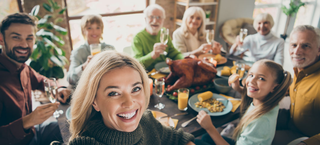 Familia durante una comida sacándose una foto mientras celebran