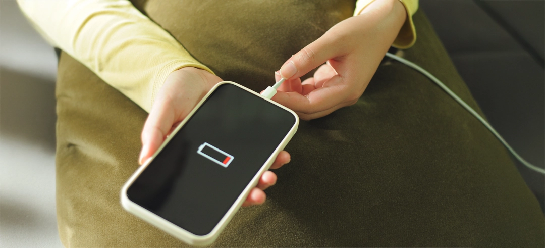 Teléfono mostrando batería a punto de agotarse mientras se carga