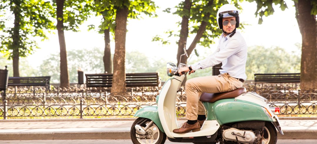 Chico joven conduciendo una moto scooter